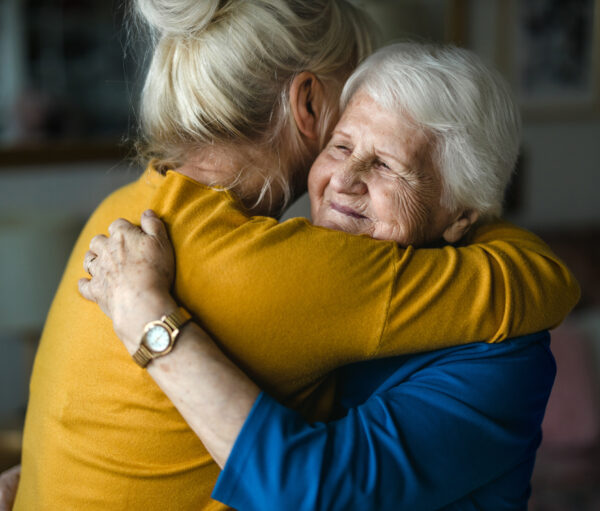 Woman hugging her elderly mother